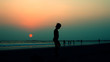 © victoria chaikova - silhouette of a child on a sunset background in the sea or ocean on a beach in summer during vacation in Goa, India