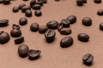 close up of roasted coffee beans isolated on brown background