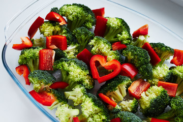 A mix of broccoli and bell pepper (paprika) in the glass baking dish with the heart made with two pieces of the bell pepper.