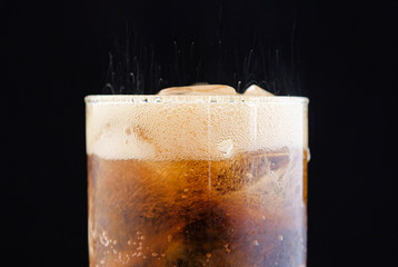 ice cube in fizzy splashing water with soda bubble