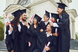 © Studio Romantic - A group of graduates with scrolls in their hands are smiling