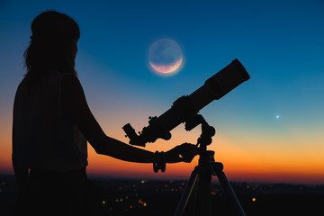 Wall Mural - silhouette of a woman and telescope with twilight sky.