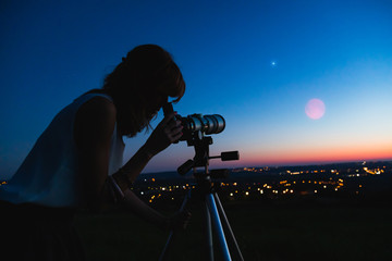 Wall Mural - silhouette of a woman and telescope with twilight sky.