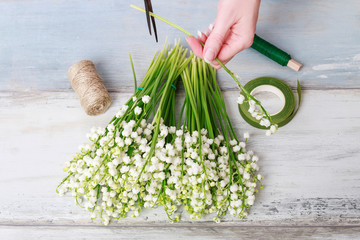 Wall Mural - Woman cuts the lilly of the valley stems