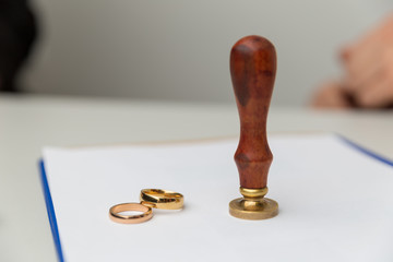 Wall Mural - Divorce in process. Woman and man signing document. Wedding rings on the table