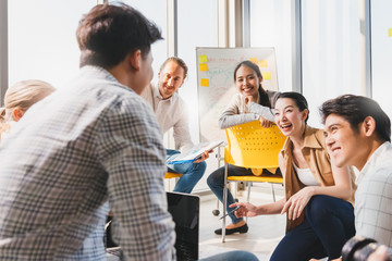 Wall Mural - Group asian young modern people in smart casual wear having a brainstorm meeting while sitting in office background. Business presentation, Planning, Strategy, New business development,Startup concept