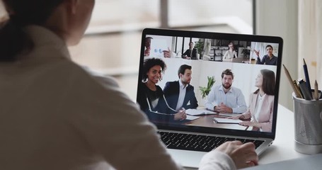 Wall Mural - over shoulder back closeup view of business woman video conference calling multiracial businesspeopl