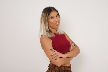 Pretty caucasian lady standing against gray wall with arms crossed wearing casual clothes. Looking and smiling at the camera. Confident successful woman.