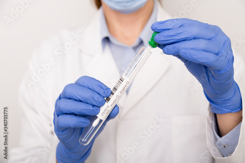 Cuadros en Lienzo Covid test in the hands of a nurse with blue gloves