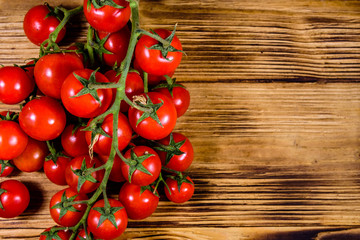 Heap of small cherry tomatoes on wooden table. Top view