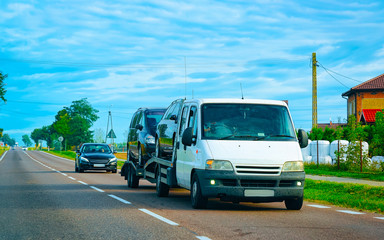 Wall Mural - Car carrying trailer with new vehicles at road in Slovenia reflex