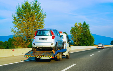 Canvas Print - Tow truck transporter carrying car in Road in Slovenia reflex