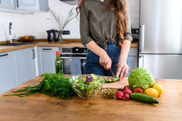 A young woman preparing a salad at home