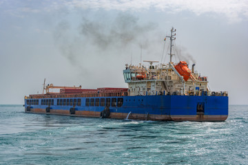 Wall Mural - Small multipurpose dry cargo vessel also known locally as barges, used to feed the mother vessels as the bigger vessel sometimes, by itself, could not be anchored at the harbor.