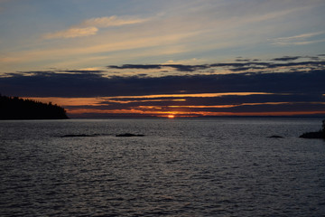 Wall Mural - Beautiful sunset over the lake in gray clouds. The concept of relaxation and a healthy lifestyle.