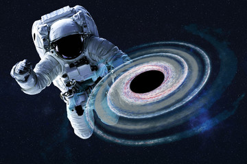 Wall Mural - astronaut near colourful black hole somewhere in space. dramatic space background. science fiction. 