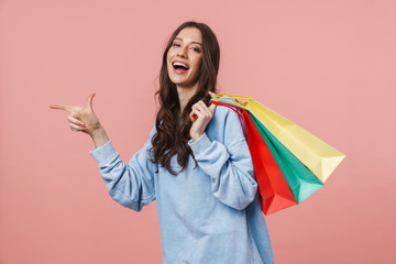 Poster - Image of young woman pointing finger while holding shopping bags