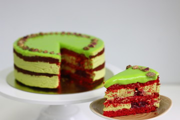 Wall Mural - Raspberry cake with pistachio on a light background. red velvet cake. sliced dessert closeup