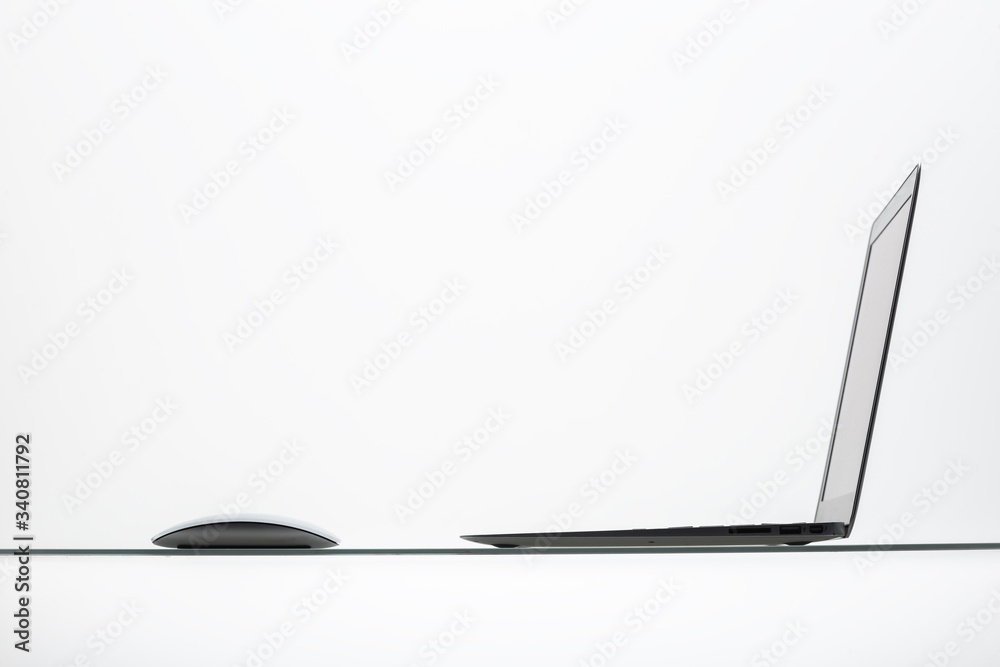 Computer Inclined computer mouse under inverted laptop on inclined glass table surface ...