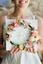 Woman Holding Card With Flower Wreath