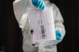 Fototapeta  - Coronavirus testing, a hand holds transparent bag with tube of blood test samples of coronavirus (COVID-19).