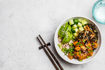 Canvas Print - Vegan ahi poke bowl with tofu, rice, seaweed, avocado and cucumber, white background, top view.