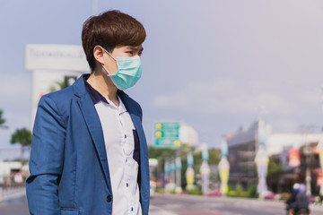 Wall Mural - The business man wearing protection face mask against coronavirus, PM 2.5 and cold while standing on escalator. Coronavirus and Air pollution pm 2.5 concept.