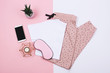 © Yulia Lisitsa - A t-shirt and sweat pants on pink and white background.  Flat lay, top view.