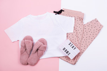 A t-shirt and sweat pants on pink and white background.  Flat lay, top view. 