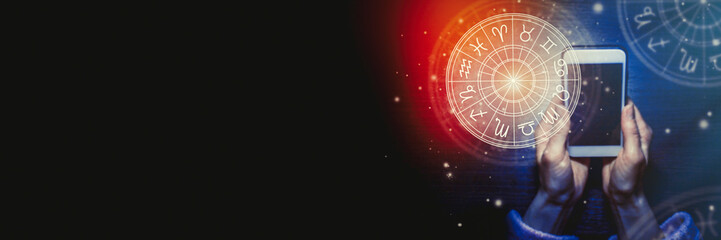 Wall Mural - female hands are holding a phone and an astrological circle with the familiar zodiac against a starr