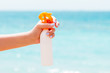 © sosiukin - Croped image of woman's hand holding sunblock spray at the beach