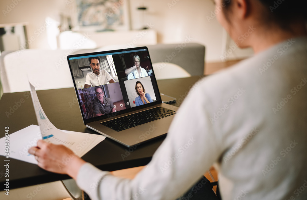 Businesswoman at home having a video conference with her team - obrazy, fototapety, plakaty 