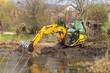 Crawler excavator or digger dredges on the lake