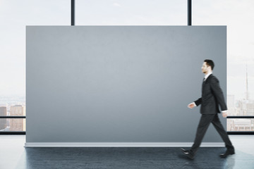 Poster - Businessman walking in clean gallery interior