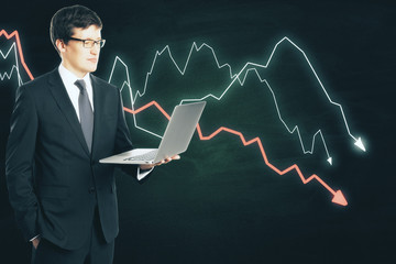Poster - Businessman holding laptop and drawing crisis chart