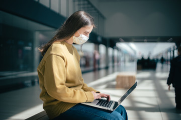 young woman works on a laptop in an empty business center building