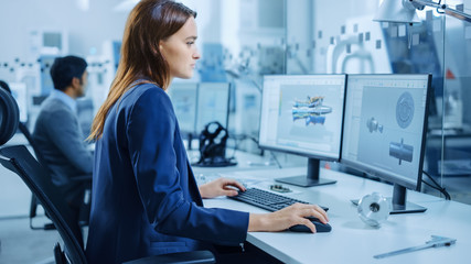 Wall Mural - Over the Shoulder: Team of Mechanical Engineer Working on Personal Computers, Screens Shows CAD Software with 3D Prototype of Electric Engine, Turbine. Industrial Factory with High-Tech CNC Machinery