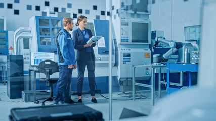 Aufkleber - Factory Workshop: Professional Female Engineer and Male Machinery Operator Use Industrial Digital Tablet Computer to Program Robot Arm for Production Line. High-Tech Facility with CNC Machines