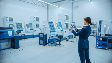Poster - Modern Factory: Female Engineer Uses Digital Tablet Computer with Augmented Reality Software to Visualize Workshop for Room Mapping, Floor Layout. Facility with High-Tech CNC Machinery and Robot Arm