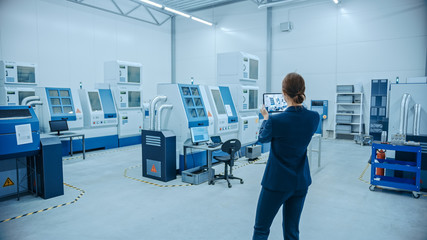 Poster - Modern Factory: Female Engineer Uses Digital Tablet Computer with Augmented Reality Software to Visualize Workshop for Room Mapping, Floor Layout. Facility with High-Tech CNC Machinery and Robot Arm
