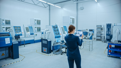 Poster - Modern Factory: Female Engineer Uses Digital Tablet Computer with Augmented Reality Software to Visualize Workshop for Room Mapping, Floor Layout. Facility with High-Tech CNC Machinery and Robot Arm