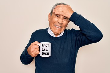 Wall Mural - Senior man drinking cup of coffee with best dad ever message over white background stressed with hand on head, shocked with shame and surprise face, angry and frustrated. Fear and upset for mistake.