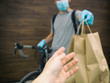 © SkyLine - The courier on the bicycle is delivering the paper bag with order to the person