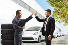  Auto Mechanic Gesturing High-five With A Professional Man Outside A Car Service Building