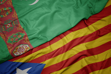 waving colorful flag of catalonia and national flag of turkmenistan.