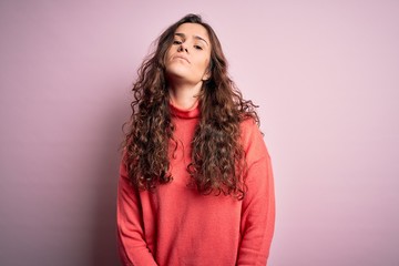 Sticker - Young beautiful woman with curly hair wearing turtleneck sweater over pink background Relaxed with serious expression on face. Simple and natural looking at the camera.