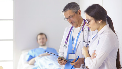 Wall Mural - Doctor checking heart beat of patient in bed with stethoscope