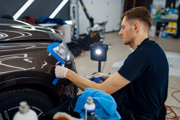 Wall Mural - Worker prepares car to applying of protection film