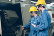 © iStocker - technician and Apprentice operate talking and discussion to  automated CNC in factory