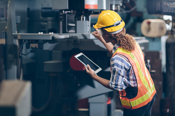 profession technician women checklist on Tablet to  automated CNC in factory